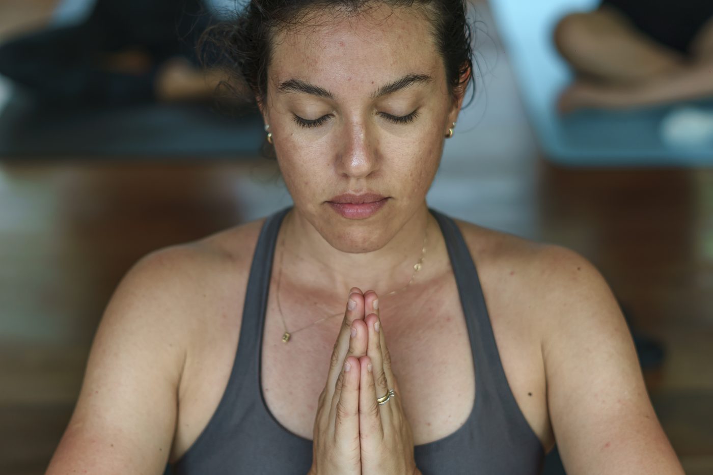 Aluna em meditação com as mãos em oração